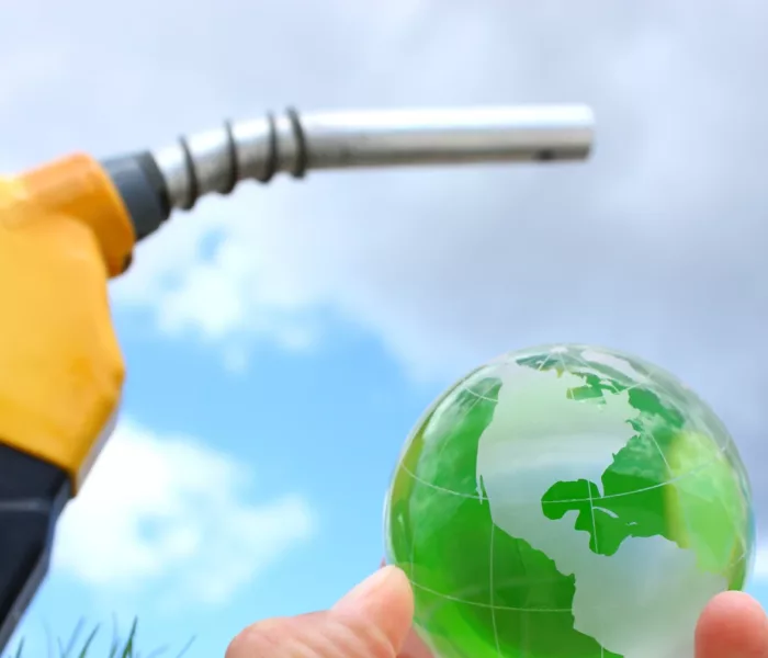 Pompe à carburant et globe, symbole d’enjeux pour la décarbonation et l’écologie mondiale ; Fuel pump and globe, symbols of the challenges of decarbonization and global ecology ; Kraftstoffpumpe und Globus als Symbol für die Herausforderungen der Dekarbonisierung und der globalen Ökologie