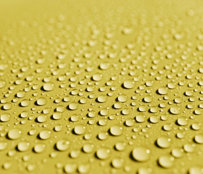 gouttes d'eau sur un matériau de surface jaune ; water droplets on a yellow surface material ; Wassertropfen auf einem gelben Oberflächenmaterial
